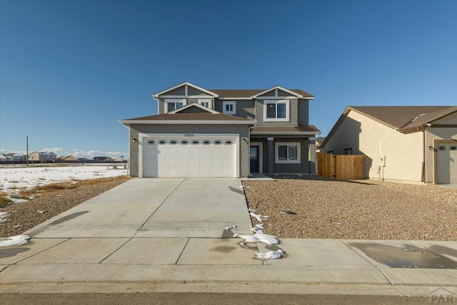 view of front of property with a garage, fence, concrete driveway, and stucco siding