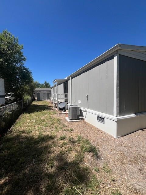 exterior space with crawl space, fence, and cooling unit