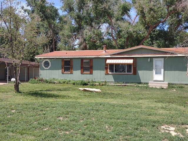 manufactured / mobile home featuring a carport, metal roof, and a front lawn