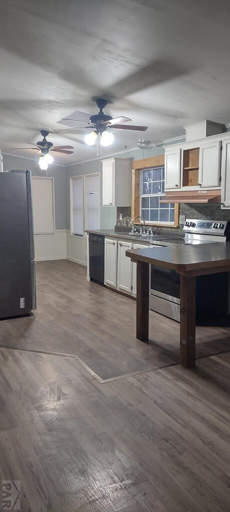kitchen with white cabinetry, black dishwasher, freestanding refrigerator, decorative backsplash, and dark countertops
