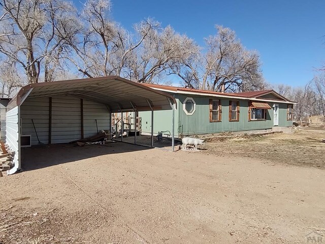 exterior space with a carport and dirt driveway