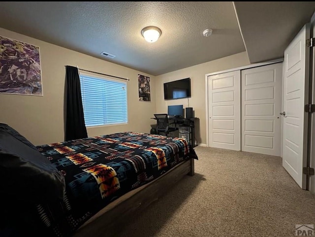 1427 E Kiva Dr, Pueblo West, CO 81007 - carpeted bedroom featuring a closet and a textured ceiling