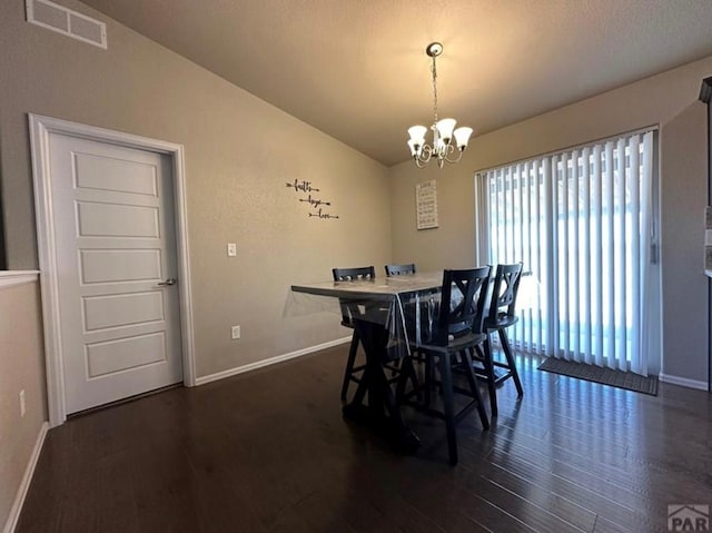 1427 E Kiva Dr, Pueblo West, CO 81007 - dining space with dark wood-style floors, a chandelier, and vaulted ceiling