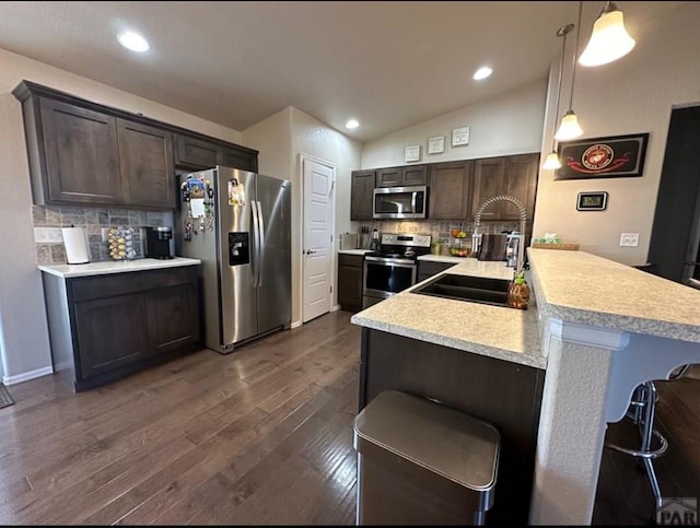 1427 E Kiva Dr, Pueblo West, CO 81007 - kitchen featuring stainless steel appliances, light countertops, dark brown cabinetry, decorative backsplash, and recessed lighting