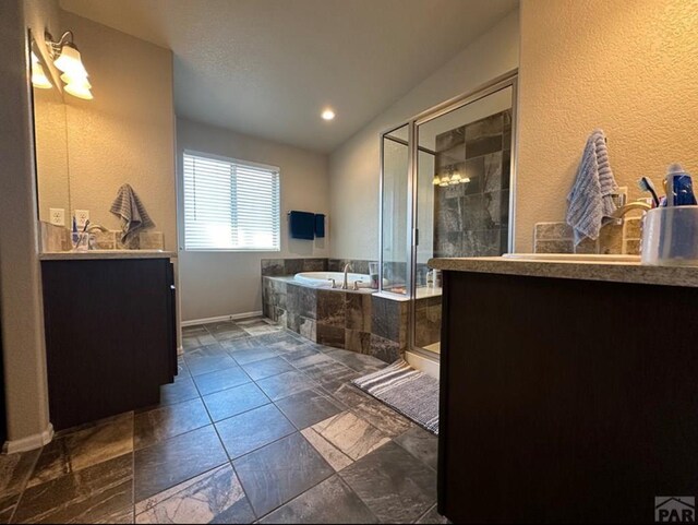 1427 E Kiva Dr, Pueblo West, CO 81007 - bathroom with vanity, a garden tub, a stall shower, lofted ceiling, and a textured wall