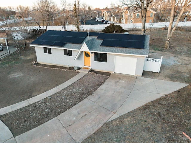 single story home with stucco siding, fence, a residential view, concrete driveway, and a shingled roof