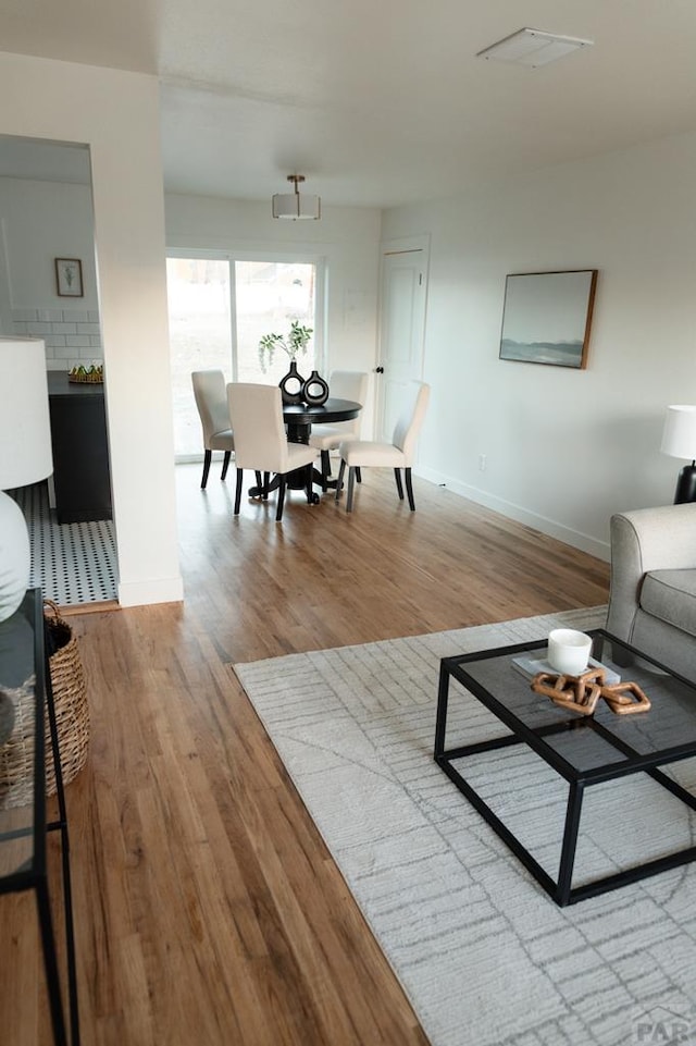 living area featuring baseboards and wood finished floors