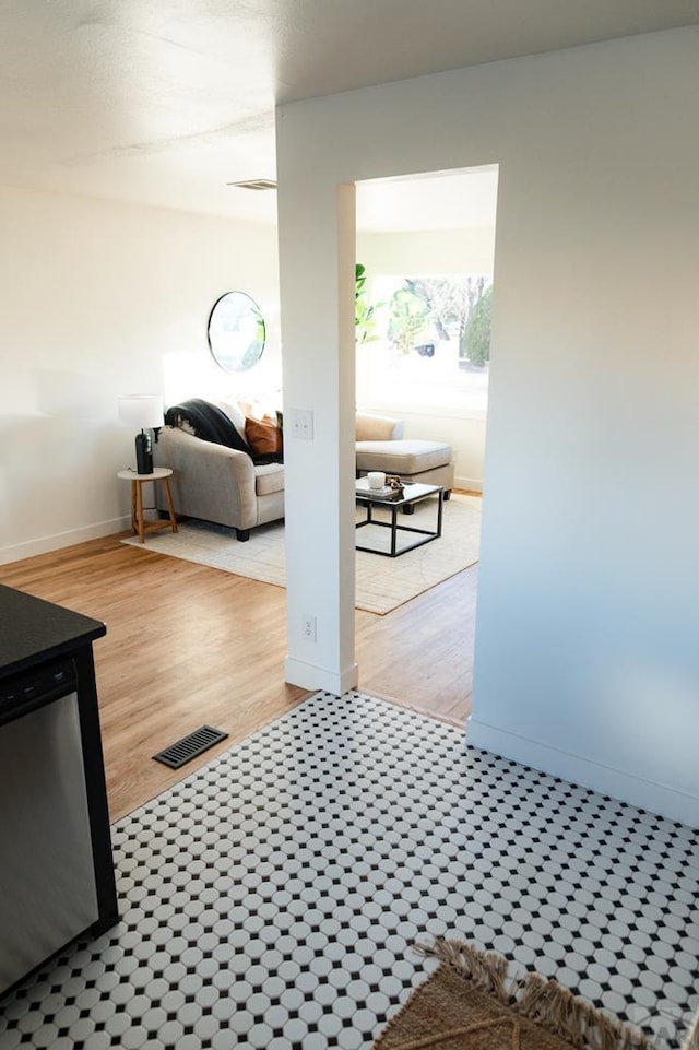 hall with visible vents, baseboards, and wood finished floors