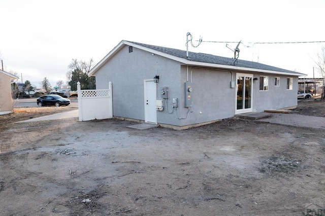 back of house with fence and stucco siding