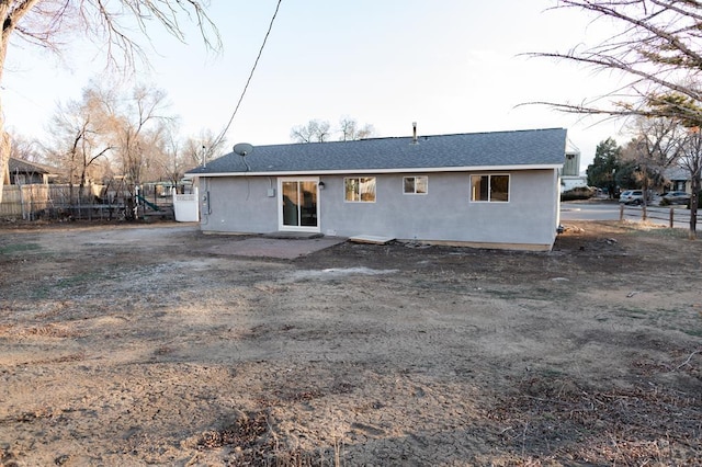 back of property with fence and stucco siding