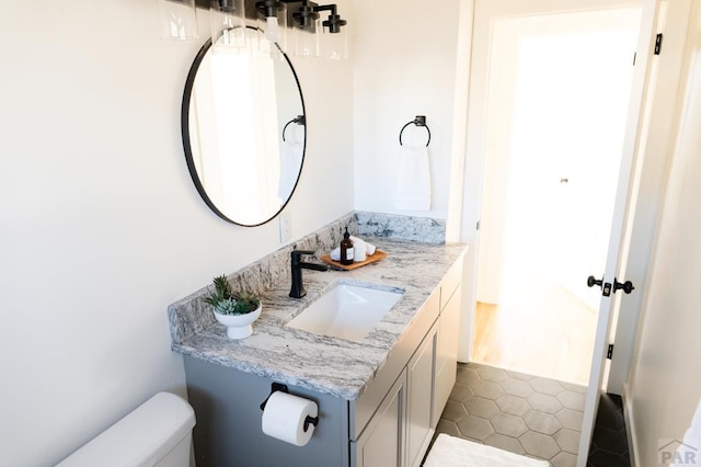 bathroom with toilet, tile patterned flooring, and vanity