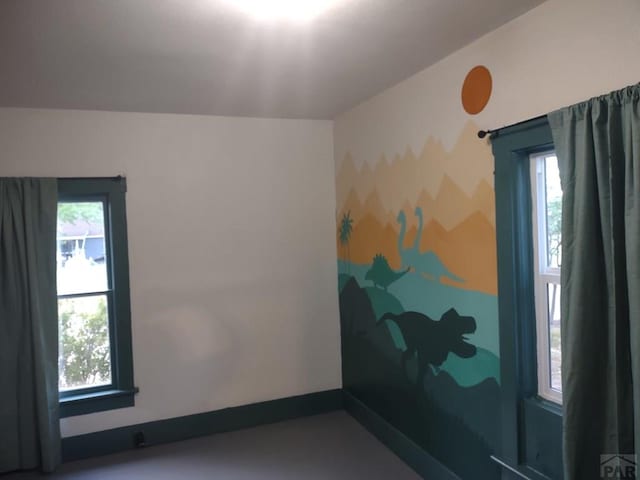 spare room with a wealth of natural light and baseboards