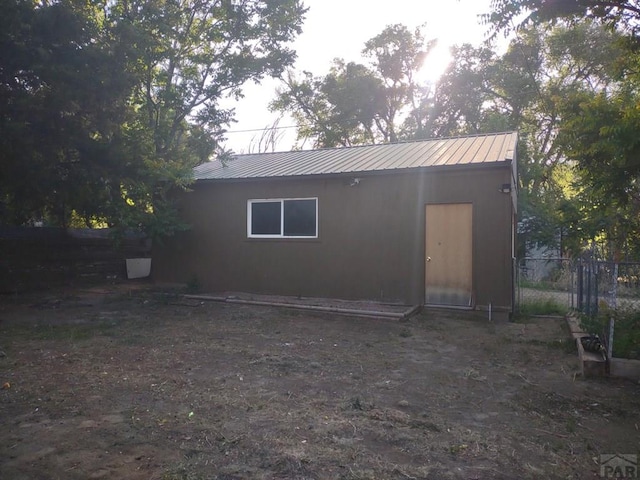 exterior space with metal roof and fence
