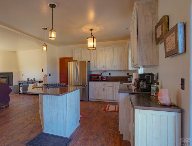 kitchen featuring dark countertops, a kitchen island, a breakfast bar area, and stainless steel appliances