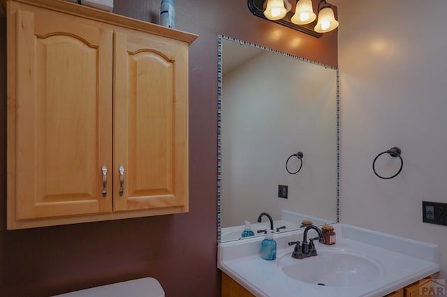 bathroom with a sink, toilet, and an inviting chandelier