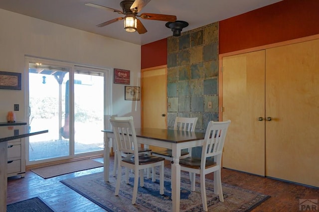 dining space with ceiling fan and wood finished floors