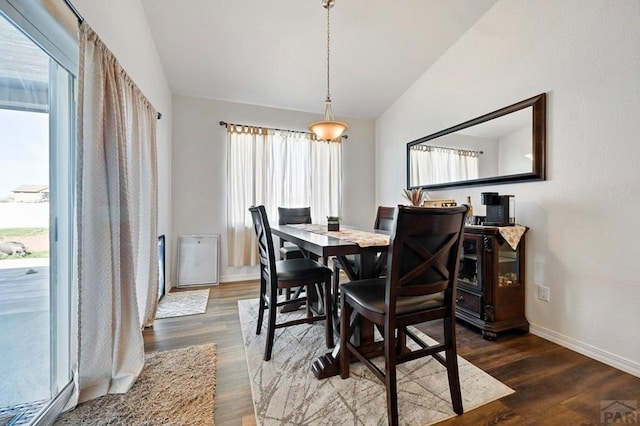 dining area featuring lofted ceiling, dark wood-style flooring, and baseboards