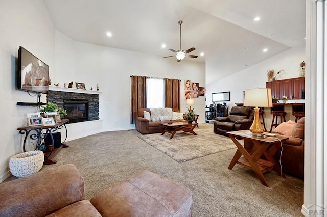 carpeted living room featuring high vaulted ceiling, a stone fireplace, recessed lighting, a ceiling fan, and baseboards