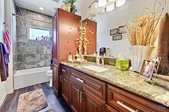 full bathroom with toilet, bathtub / shower combination, wood finished floors, and vanity