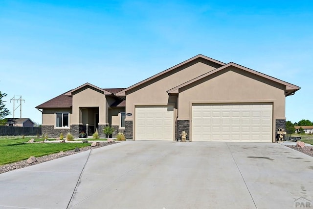 view of front facade featuring stucco siding, fence, a garage, stone siding, and driveway