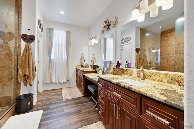 full bathroom with a stall shower, wood finished floors, vanity, and baseboards