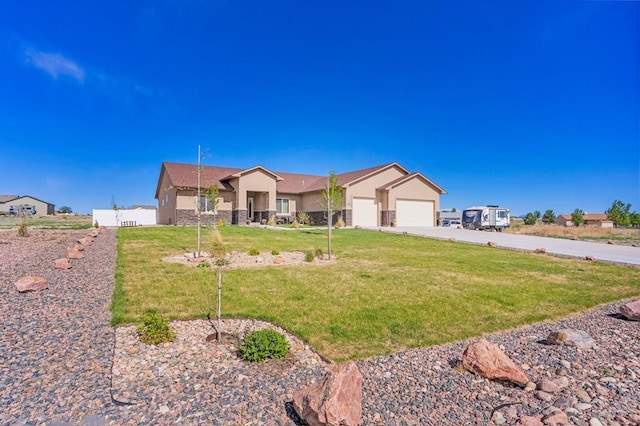 ranch-style home featuring stucco siding, a front yard, a garage, stone siding, and driveway