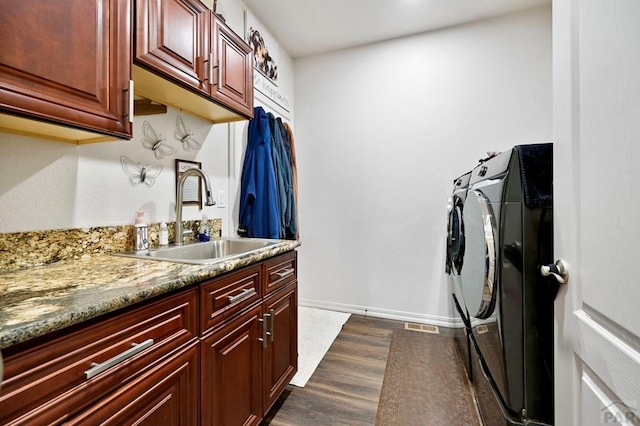 laundry area with separate washer and dryer, dark wood-style flooring, a sink, baseboards, and cabinet space