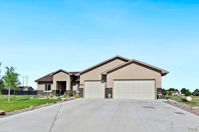 view of front of home featuring stone siding, concrete driveway, an attached garage, and stucco siding