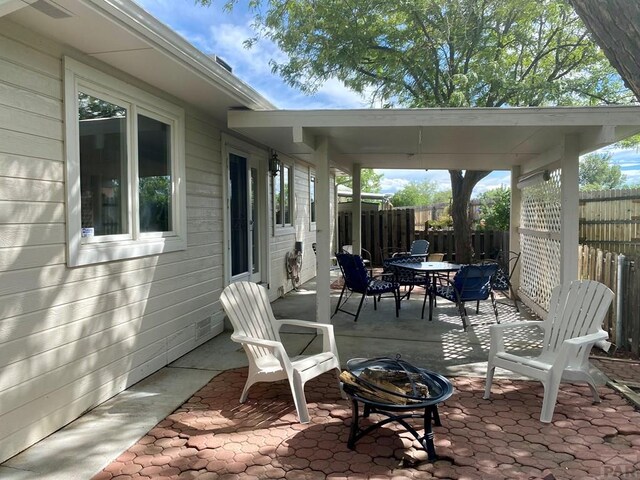 view of patio featuring an outdoor fire pit, outdoor dining area, and fence