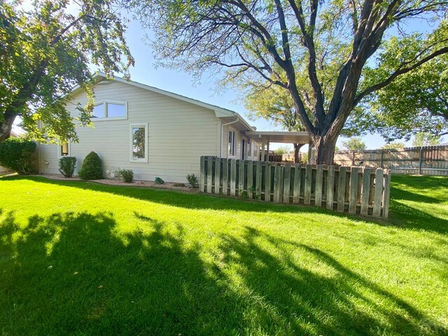 exterior space with fence and a lawn