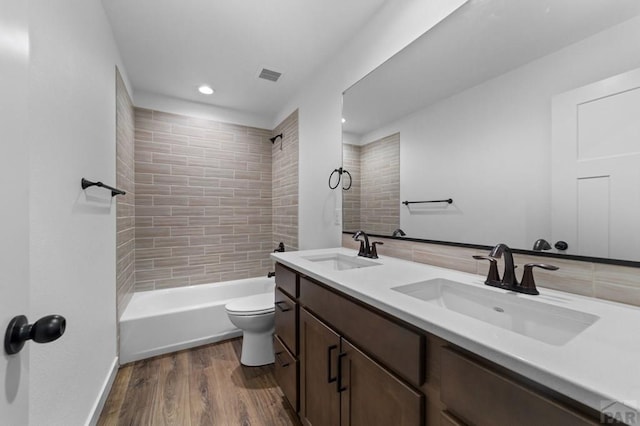 bathroom featuring wood finished floors, a sink, recessed lighting, and toilet