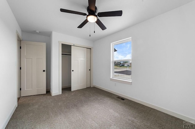 unfurnished bedroom with a closet, carpet, visible vents, and baseboards