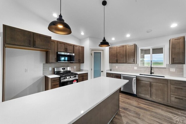 kitchen featuring a sink, decorative backsplash, stainless steel appliances, light countertops, and recessed lighting