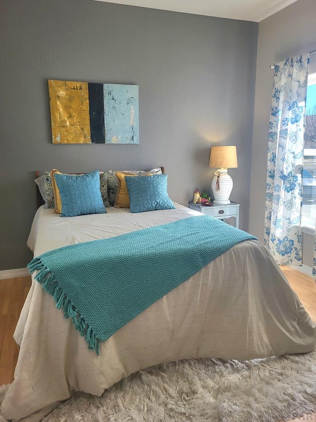 bedroom with wood finished floors and baseboards