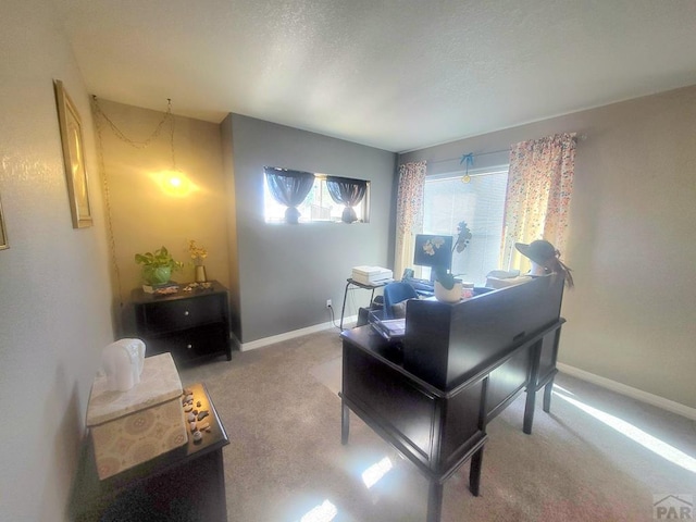 carpeted office featuring baseboards and a textured ceiling