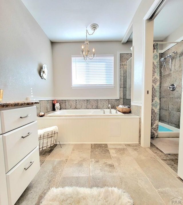 full bath with a chandelier, a garden tub, and a shower stall