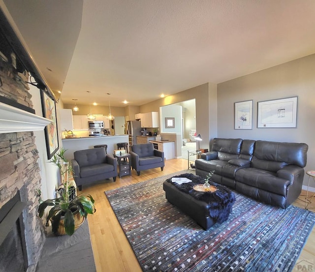 living room with light wood-type flooring and a fireplace