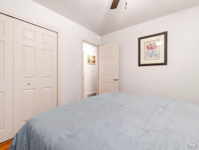 bedroom featuring visible vents, a ceiling fan, and a closet