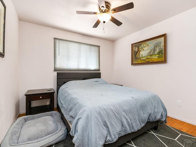 bedroom with wood finished floors, a ceiling fan, and baseboards