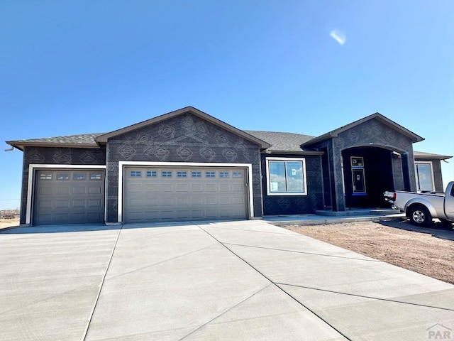 single story home featuring concrete driveway and an attached garage