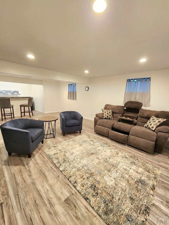 living area featuring baseboards, recessed lighting, and light wood-style floors