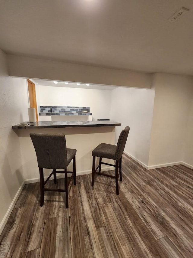 bar with dark wood-style floors and baseboards