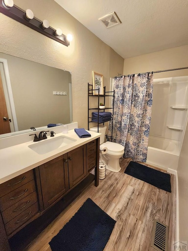 bathroom featuring shower / tub combo, visible vents, wood finished floors, and vanity