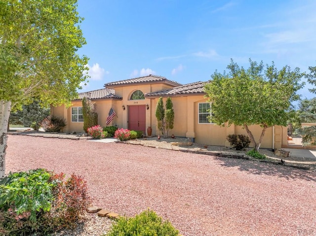 348 S Tejon Ln, Pueblo West, CO 81007 - mediterranean / spanish home with a tile roof, stucco siding, and an attached garage