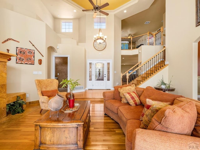 348 S Tejon Ln, Pueblo West, CO 81007 - living area featuring ceiling fan, wood finished floors, stairs, a towering ceiling, and arched walkways