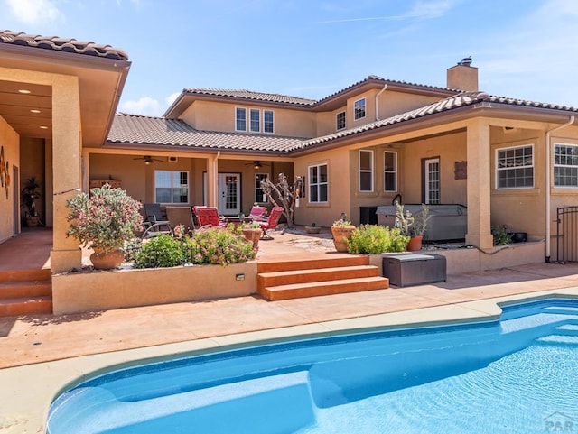 348 S Tejon Ln, Pueblo West, CO 81007 - back of property with a ceiling fan, a patio area, stucco siding, a tiled roof, and a jacuzzi