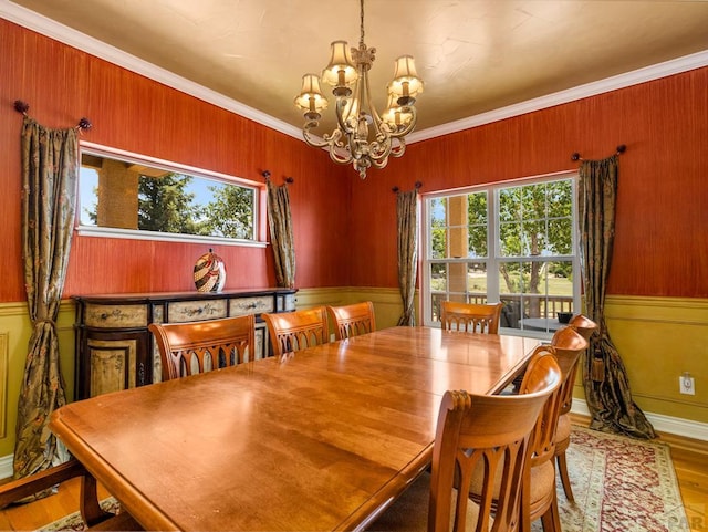 348 S Tejon Ln, Pueblo West, CO 81007 - dining room featuring a chandelier, ornamental molding, wood walls, and wood finished floors