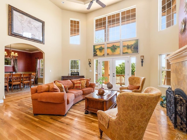 348 S Tejon Ln, Pueblo West, CO 81007 - living area with a towering ceiling, light wood finished floors, plenty of natural light, arched walkways, and a chandelier