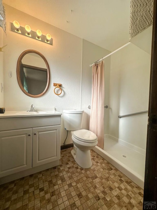 bathroom featuring toilet, vanity, and curtained shower
