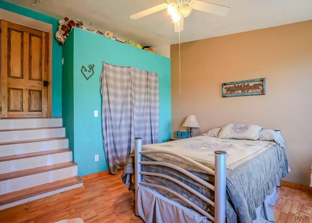 bedroom with light wood-type flooring, baseboards, and ceiling fan